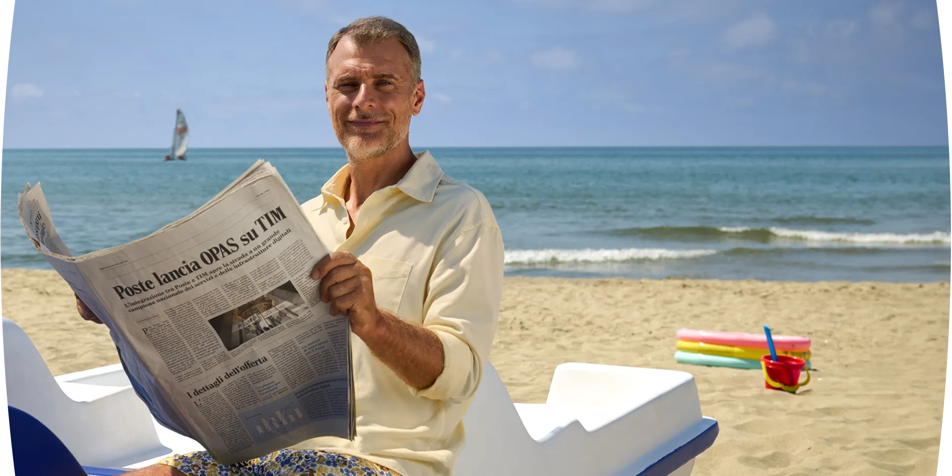 un uomo legge un giornale in spiaggia