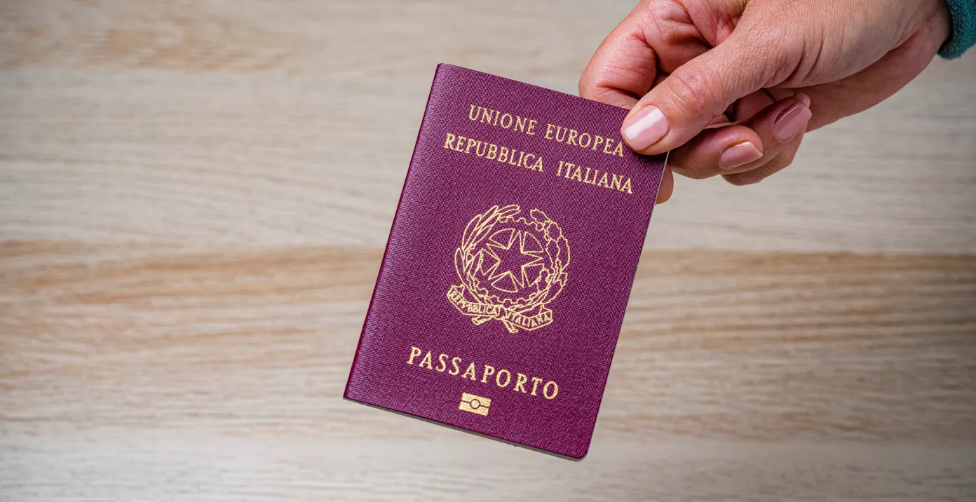 Mano che regge un passaporto italiano