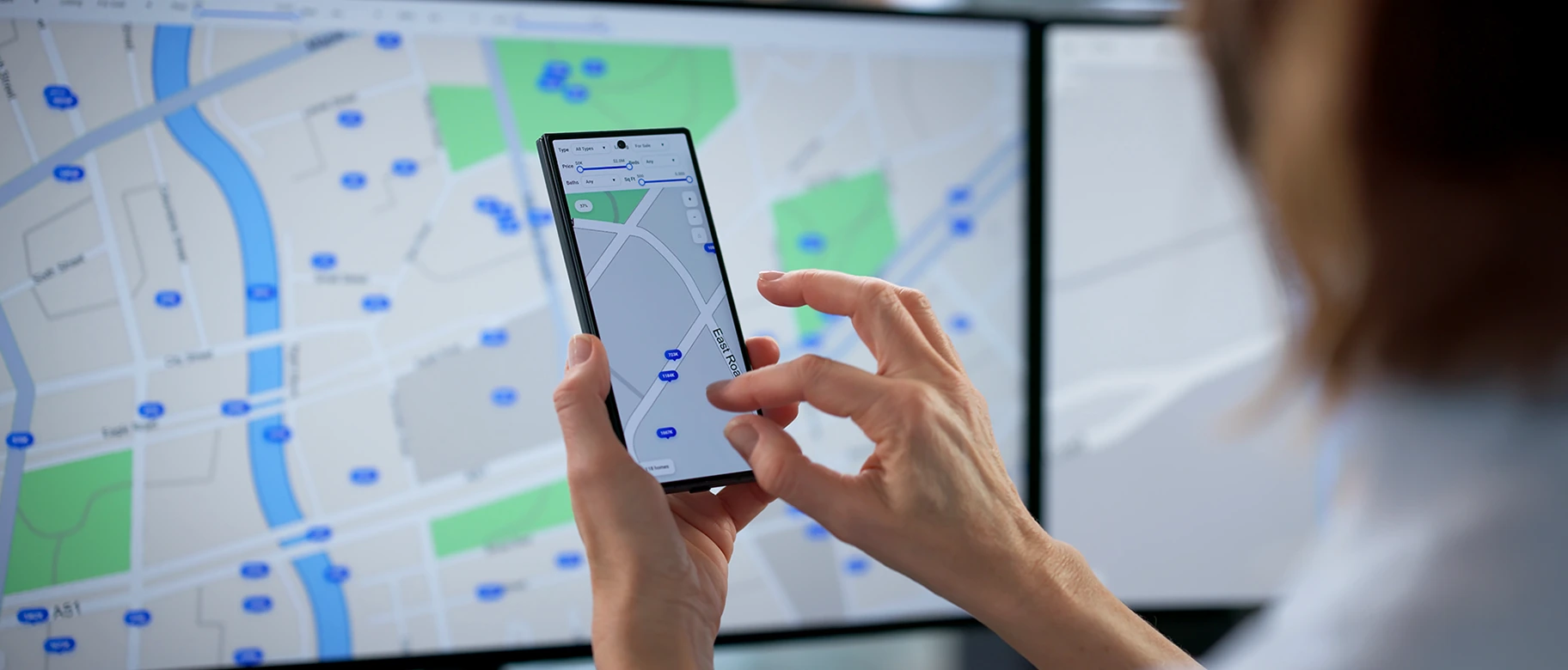 Persona con smartphone consulta una mappa