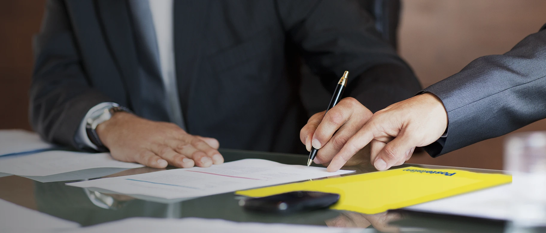 Primo piano di una mano che firma un documento