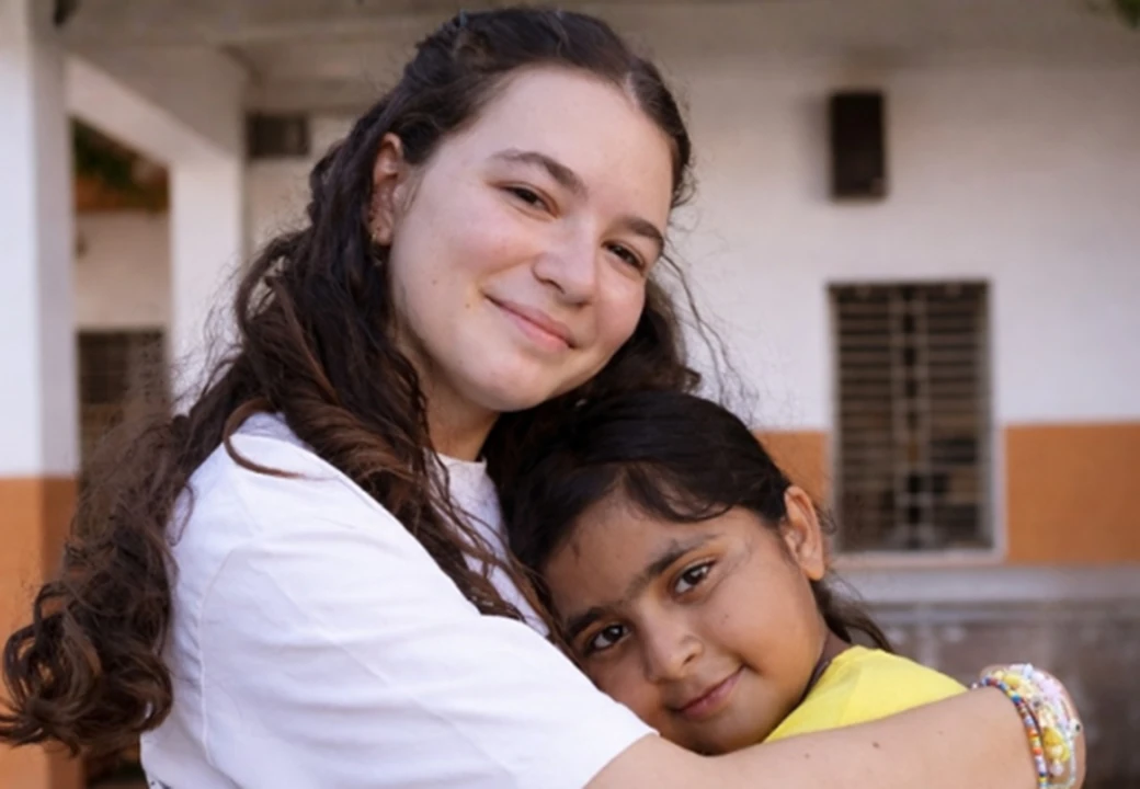 operatrice sociale abbraccia bambina