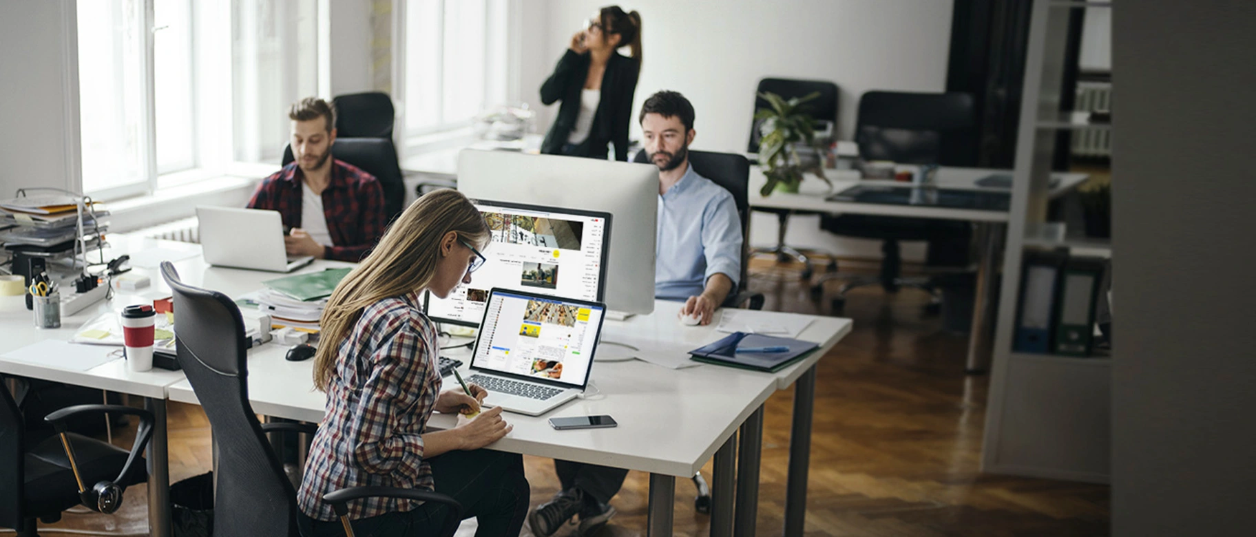 Redazione con persone davanti a monitor PC