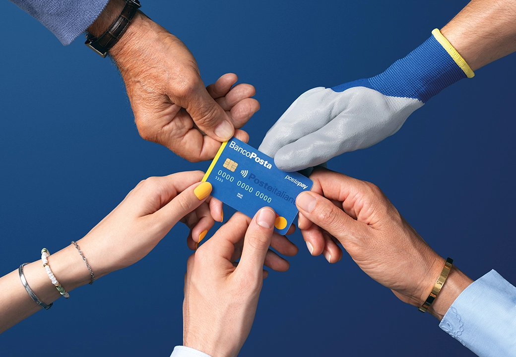 Diverse mani reggono una carta Postamat